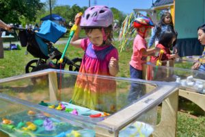 Little girl plays at the tiny house's water table