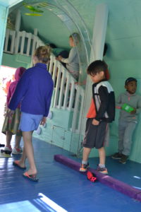 Kids walk through the tiny playhouse