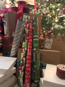 Wrapping paper and boxes in front of the Christmas tree.