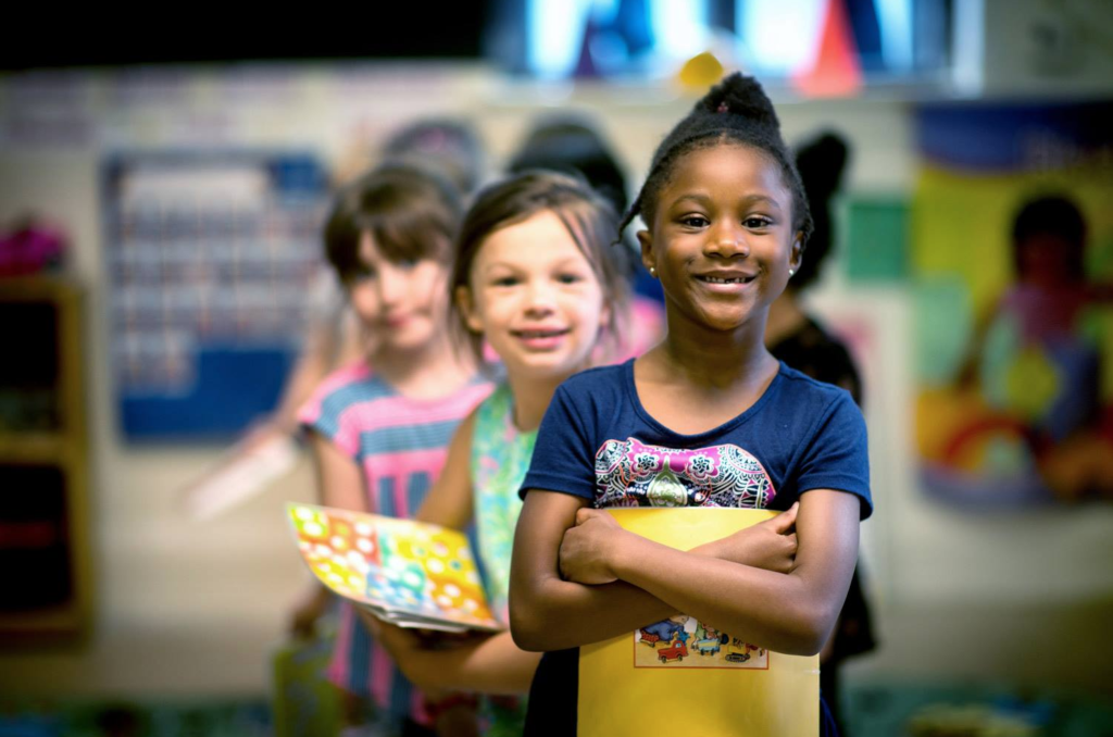 Pre-k students stand in line proudly and look at camera