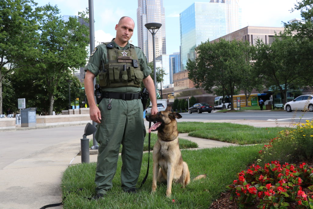 Mecklenburg County Sheriff's Deputy Beckham poses with his K-9 Atos.