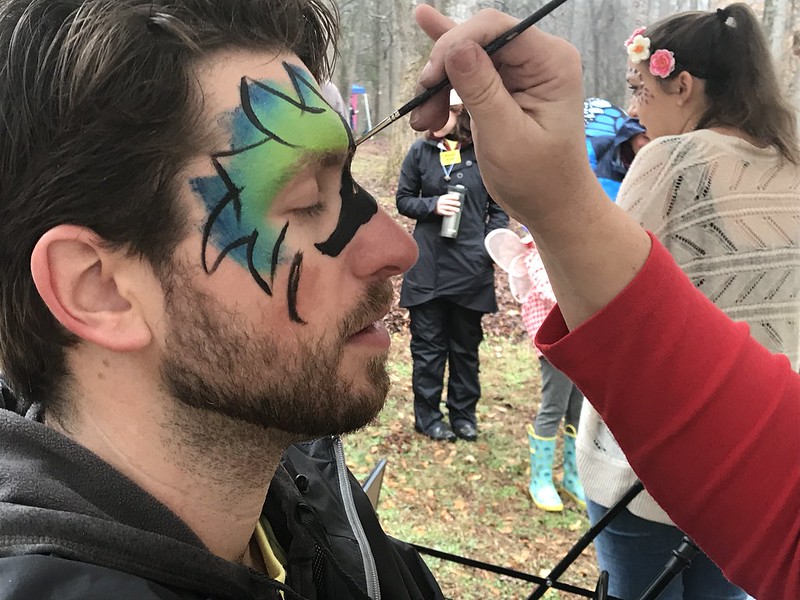 man getting face painted at the fairy house festival