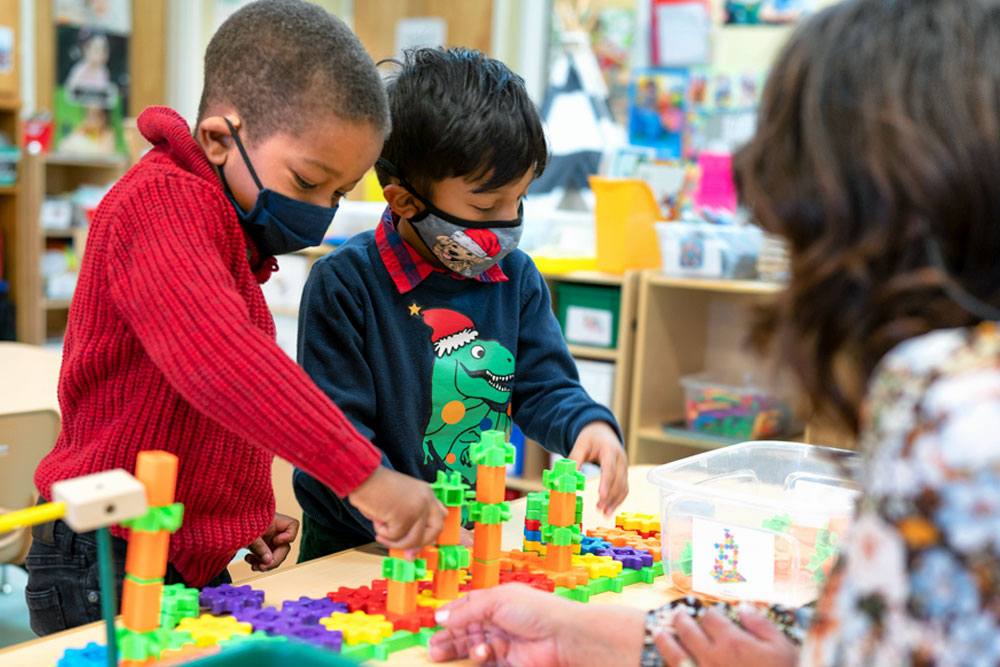 two children in pre-k playing with blocks