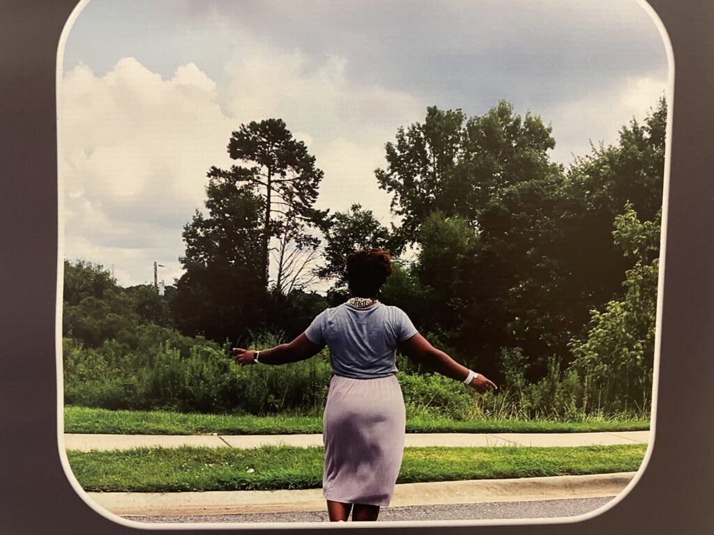 A woman standing in the street with her back facing the camera