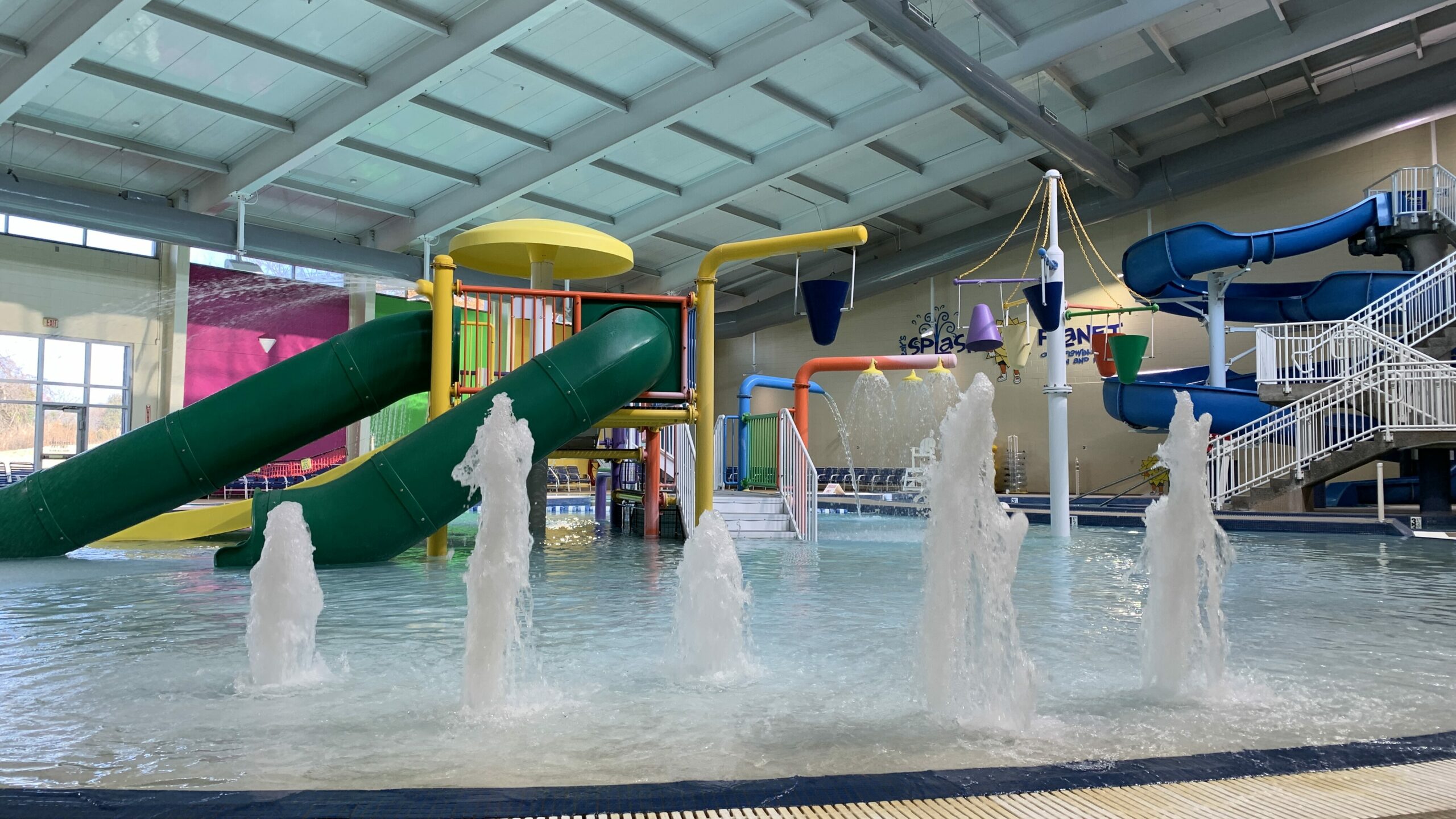 An indoor water park with fountains and slides. 