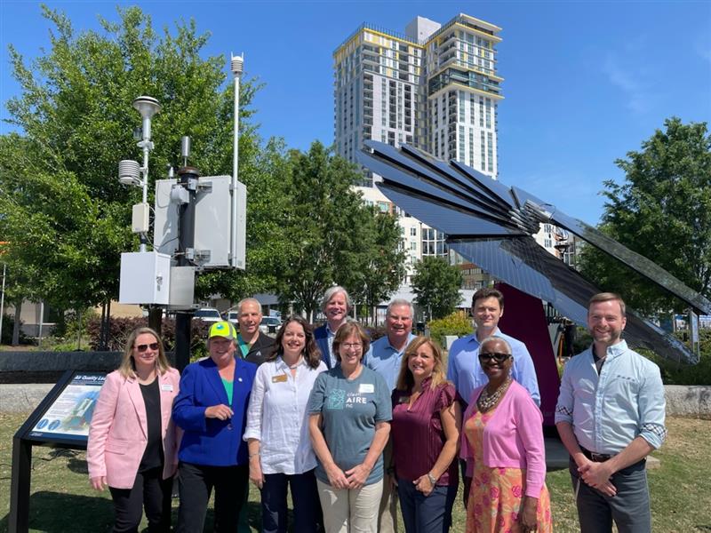 Air Quality Commission standing in front of the air quality learning station with members of the Board of County Commissioners and County staff