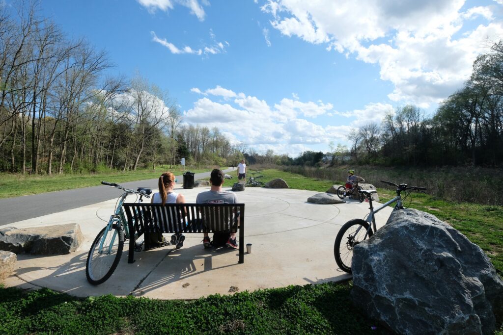 People sitting on a bench with their bikes on a trail