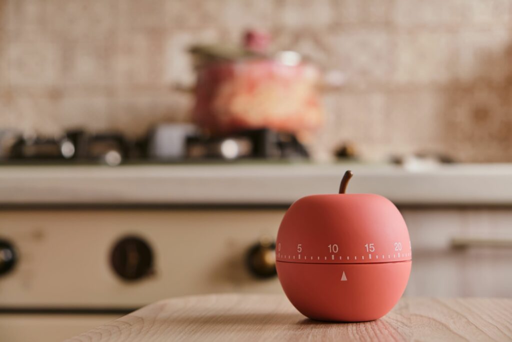 Kitchen timer shaped as an apple sitting on a kitchen counter.