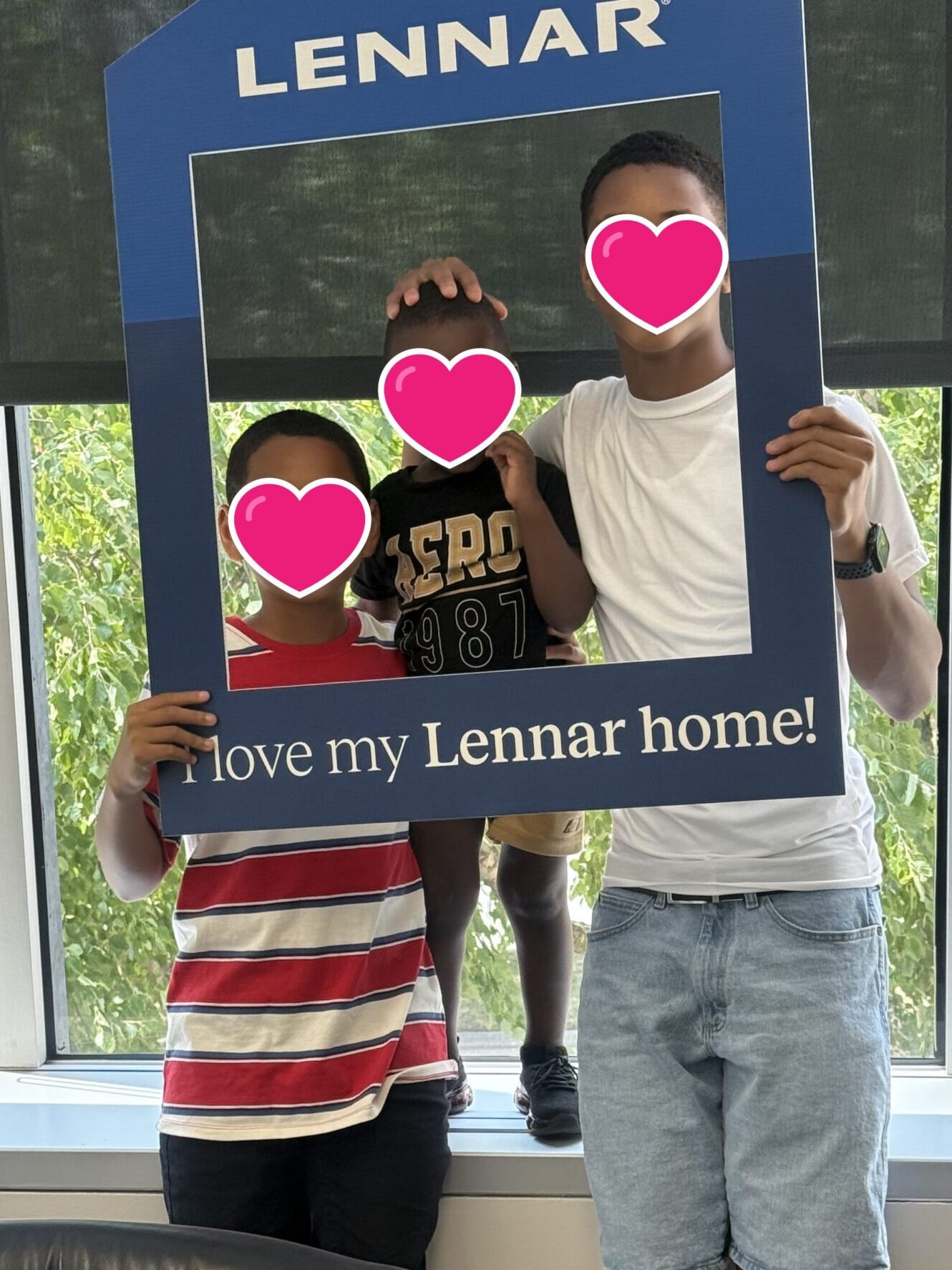 Three foster sons holding up a frame that says Lennar: I love my Lennar home